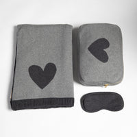 Cozy gray blanket with heart design, gray pouch with heart, and matching gray sleep mask on a white background