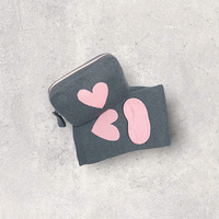 Grey organic cotton travel blanket and pink eye mask set with a grey and pink heart travel pouch for women, ready for airplane or road trip travel.