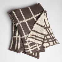 Moss-knit cotton throw blanket with brown and white plaid pattern on a light gray background.