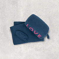 Navy blue pouch with 'LOVE' text in pink and matching cotton travel blanket and soft eye mask on a light gray background