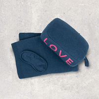 Navy blue pouch with 'LOVE' text in pink and matching cotton travel blanket and soft eye mask on a light gray background.