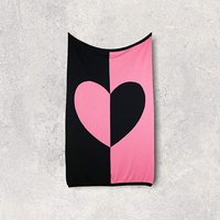 Cotton travel blanket with a pink and black heart design on a gray background