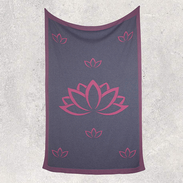 Dark gray travel blanket with pink lotus flower design on a textured white background.