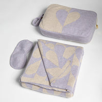 Set of gray and lavender patterned blanket with a matching heart pouch and eye mask on a light gray background.