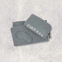 Gray cotton eye mask and compact pouch with 'DREAM' text on a light gray background.