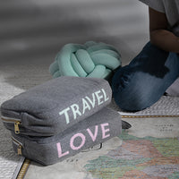 Two medium gray travel pouches with 'TRAVEL' and 'LOVE' text on top of a map.