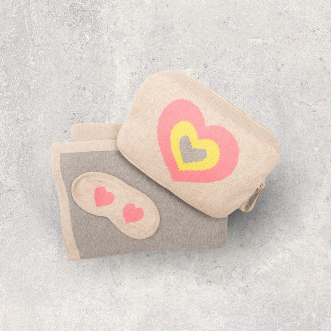 Compact travel blanket with bag and sleep mask-set. Soft organic cotton airplane blanket with a fun pink and yellow hearts design.
