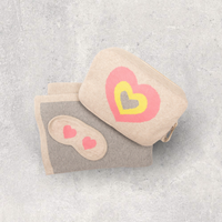 Compact travel blanket with bag and sleep mask-set. Soft organic cotton airplane blanket with a fun pink and yellow hearts design.