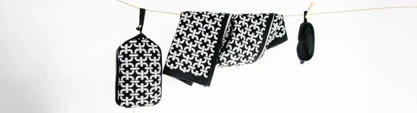 Black-and-white patterned travel accessories from Pink Lemonade hanging on a clothesline.
