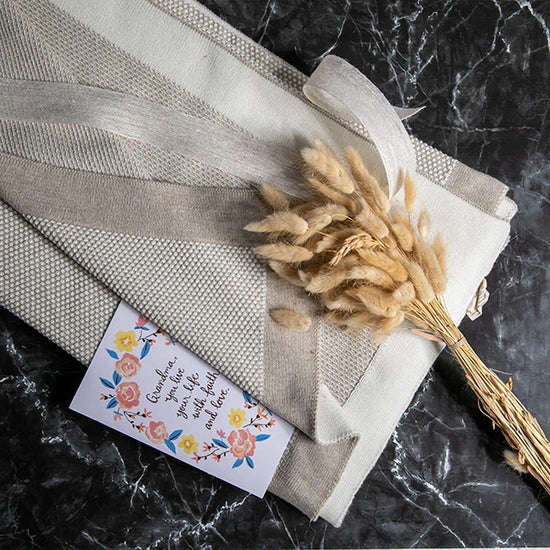 Pink Lemonade Eka Stipple organic cotton throw blanket with dried florals and a gift note.