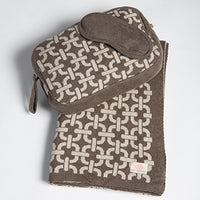Patterned travel bag with a geometric chain design and cotton eye mask on a white background