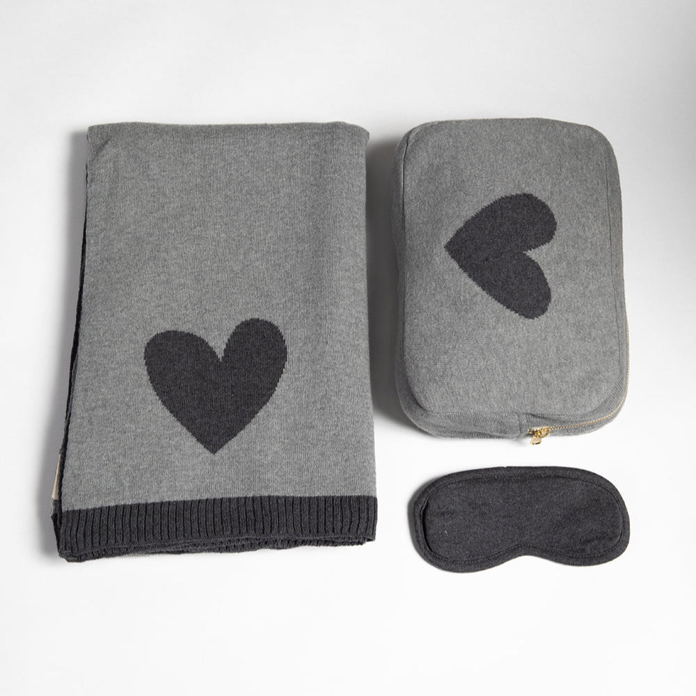 Cozy gray blanket with heart design, gray pouch with heart, and matching gray sleep mask on a white background