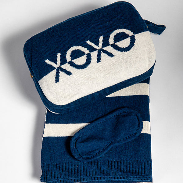 Blue and white travel blanket and pouch set with 'XOXO' text on a gray background