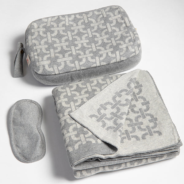 Gray chain patterned travel set with pouch, blanket, and eye mask on a white background