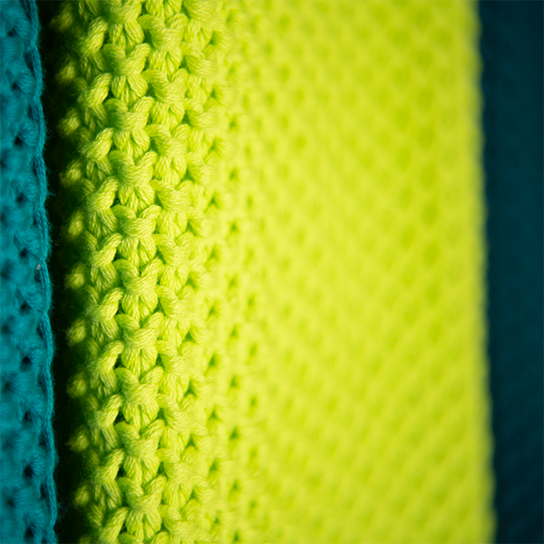Close-up of textured fabric with neon yellow and marine blue colors.