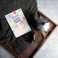 Book titled 'Only Good Things' on a wooden tray with a cup of coffee, coffee maker, and dark grey washed chevron throw.