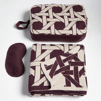 Riti organic cotton travel blanket and eye mask set with burgundy and linen geometric pattern, compact travel organiser with zip bag.