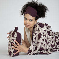 A woman's perfect travel gift: the Riti soft organic cotton blanket and eye mask travel gift set in burgundy. Compact and ideal for the airplane.