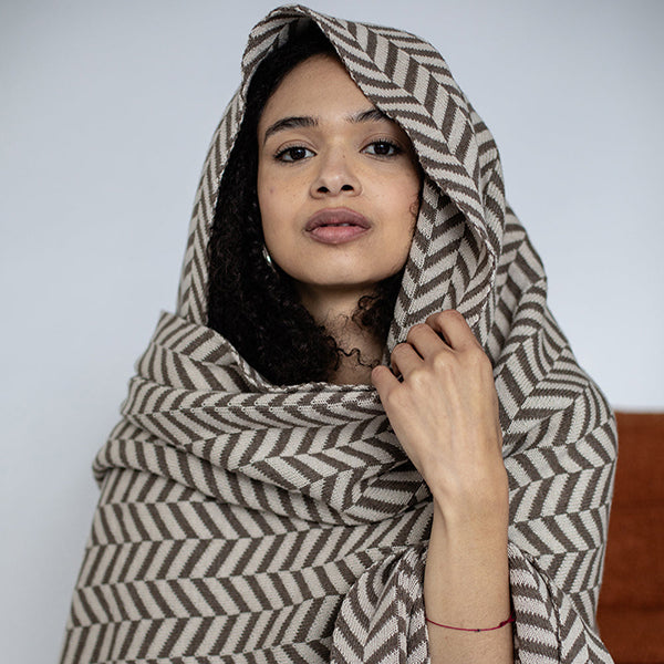 Dark brown herringbone patterned cotton throw wrapped around a girl's head.